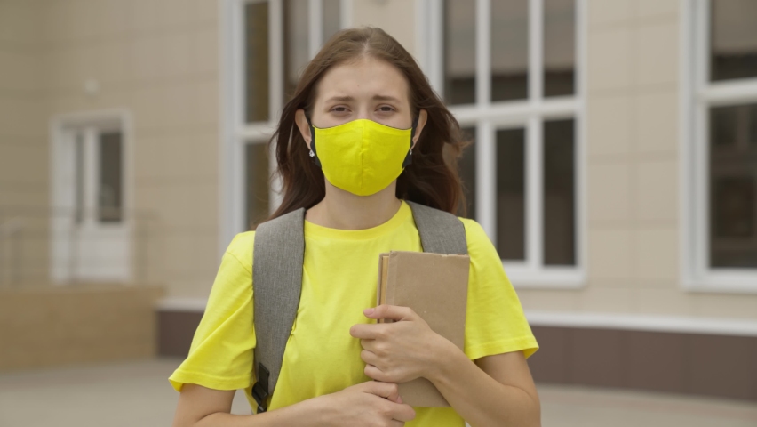 young girl with textbook in her hands, university student smiling in mask, high school student with book, education of modern society, time pass exams, coronavirus pandemic, covid 19, protect breath Royalty-Free Stock Footage #1078776743