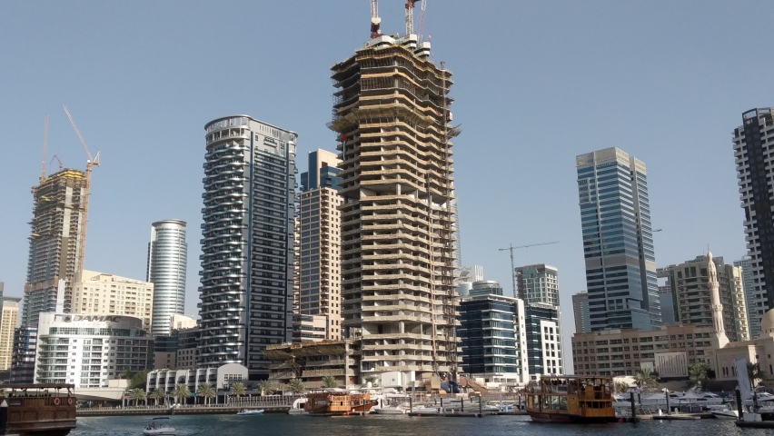 Building in construction at Dubai. The view from a yacht on the canal of Dubai Marina.
