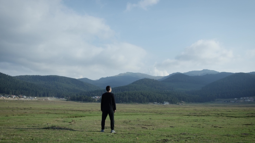 man watching big mountains and clouds