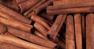 Cinnamon sticks rotate as a background. Fragrant cinnamon close-up. Spices with cinnamon. Food cooking video concept.