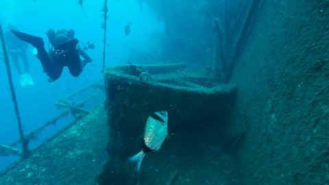 MEDITERRANEAN SEA, LIMASSOL, CYPRUS - AUGUST, 2021: Scuba diver photographer shots lifeboat on the shipwreck Swedish ferry MS Zenobia. Wreck diving. Mediterranean sea, Cyprus