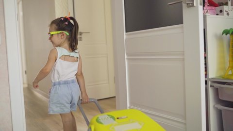 A little girl with a suitcase is going on vacation