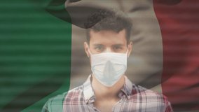 Animation of flag of italy waving over man wearing face mask during covid 19 pandemic. global covid 19 pandemic concept digitally generated video.