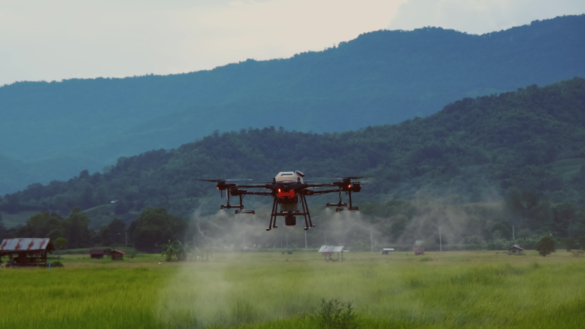 Smart farming innovation, agriculture drone fly spraying fertilizer on green rice field in countryside of Thailand, agricultural industrial technology, slow motion | Shutterstock HD Video #1078795304
