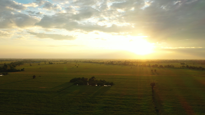Cloud moving above a field before sunset