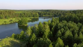Perfect bird's eye view of a calm lake and green forests on a sunny day. Location place Small Polissya, Ukraine, Europe. Cinematic aerial shot. Discover the beauty of earth. Filmed in 4k drone video.