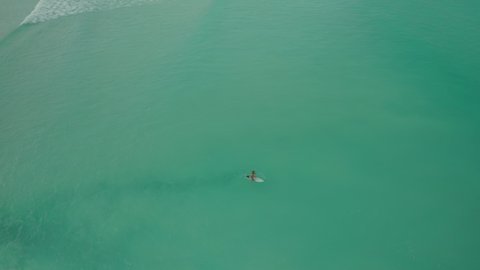 Aerial Shot Of Man Lying On Surfboard Floating Over Sea - Esperance, Australia