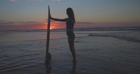 Slow Motion Shot Of Woman With Surfboard Looking At Sunset View At Beach During Vacation - Tamarindo, Costa Rica
