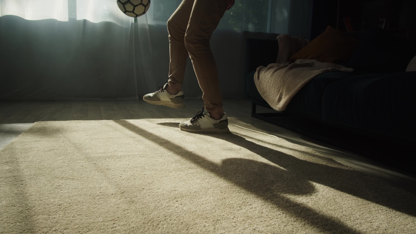 Close-up of young sportsman legs minting a soccer ball, professional football player training in the living room at home, football fan doing sport during coronavirus covid 19 lockdown. Royalty-Free Stock Footage #1078801253