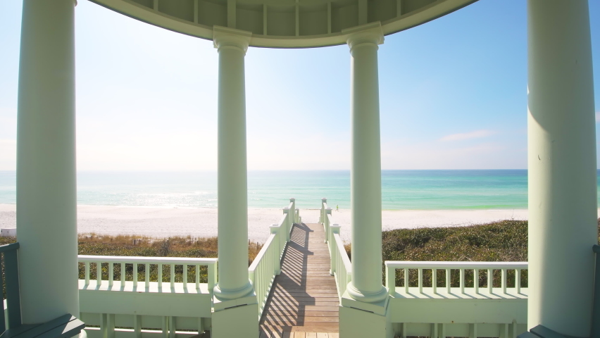 Point of view pov handheld walking on boardwalk from pavilion gazebo by sea beach at Gulf of Mexico at Seaside, Florida with new urbanism pastel blue architecture Royalty-Free Stock Footage #1078802753