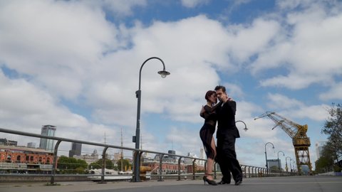 Intimate couple of dancers performing tango routine in Puerto Madero promenade