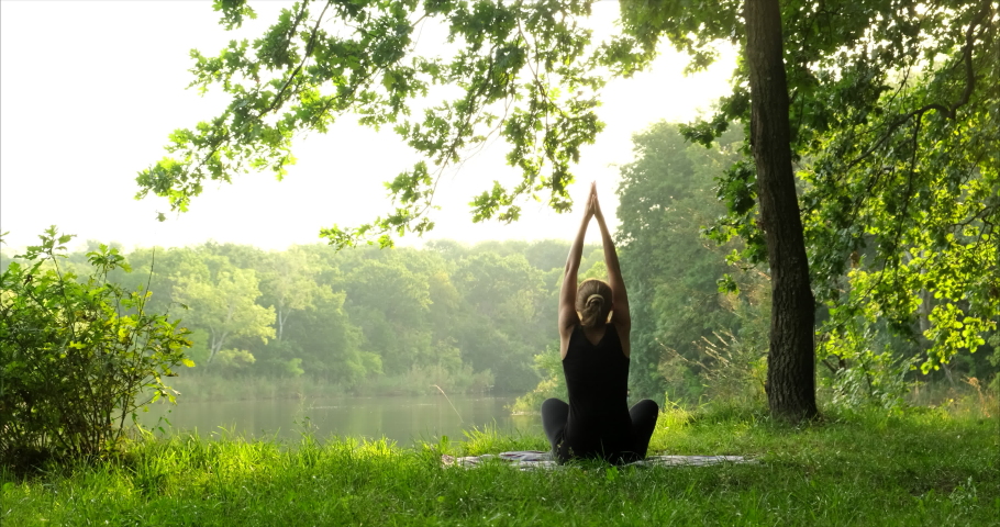 Woman meditating, zen yoga meditation practice in nature. Yogi girl is sitting in lotus pose, healthy lifestyle, meditation concept Royalty-Free Stock Footage #1078806869