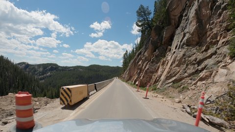 One lane narrow road under construction in high mountains leading to Yellowstone National Park, POV