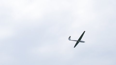 Baden-Baden, Germany - Circa 2019: Flying motorless glider low angle view of plane D-3278 Junior - calm blue sky