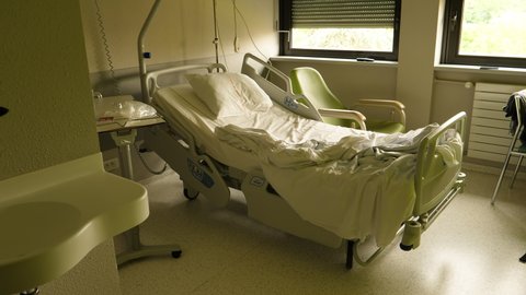 Paris, France - Circa 2021: Slow tilt-up to the empty Hill-Rom bed of a patient inside a modern hospital