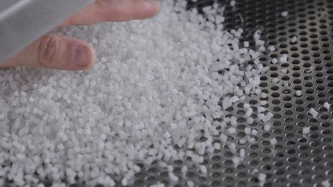 Plastic granules on a vibrating table. Polymer compound production