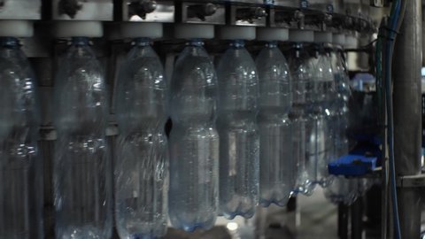 Close-up of pouring water into a plastic bottle with a volume of 1.5 liters in the filling unit. Shop for the production of mineral water and soft drinks