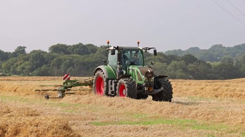 Perry Green, Much Hadham, Hertfordshire, UK. September 5th 2021. Tractor in a field raking straw with a rotary hay rake in preparation for bailing.