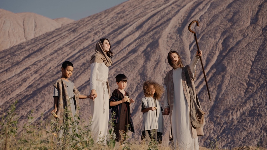 Jesus and Mary are standing on a hill showing children something in the distance. The sun is shining. High quality 4k footage