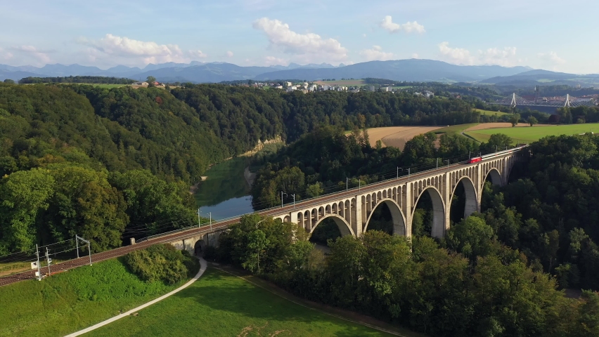 Aerial drone footage of a train crossing the famous Granfey viaduc, or bridge, over the Sarine river in Fribourg, Switzerland Royalty-Free Stock Footage #1078830866