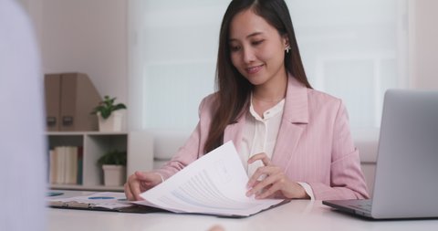 Close-up hand asia people woman fill rent loan form write legal debt letter at lawyer home office. Happy female life buy or sell new house deal from real estate sale agent. Tax advice talk and smile.