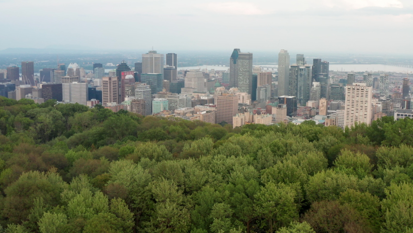 Aerial Drone of Montreal, Quebec Canada Downtown Cityscape Reveal View From Above the Trees of Mont-Royal