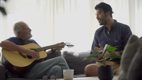 happy Senior Father play acoustic guitar with adult son sing a song together on sofa in living room at home . two generations family male music - Powered by Shutterstock - Get 15% off with code: PIKWIZARD15