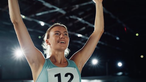 Portrait of Professional Female Athlete Happily Celebrating New Record on a Sport Championship. Determined Successful Sportswoman Raising Arms after Winning Gold Medal. Static Medium Shot