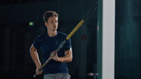 Pole Vault Jump: Portrait of Professional Male Athlete Running with Pole. Determination, Motivation, Effort of Champion in Winning. Dramatic Light, Cinematic Slow Motion Sport. Following Full Shot