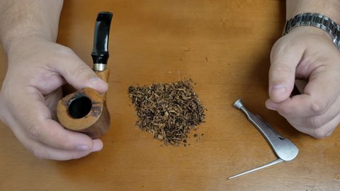 stuffing tobacco into a smoking pipe