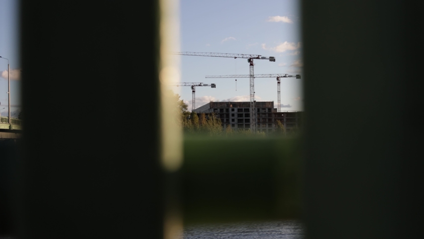 construction cranes operate on a construction site near buildings