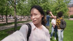 Pov shot of young asian woman smiling happy doing video call at park. Happy korean female student smiling and talking at camera having video chat outdoors