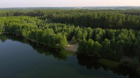 Peaceful bird's eye view of blue lakes and green forests on a sunny day. Location place Small Polissya, Ukraine, Europe. Cinematic aerial shot. Discover the beauty of earth. Filmed in 4k, drone video.