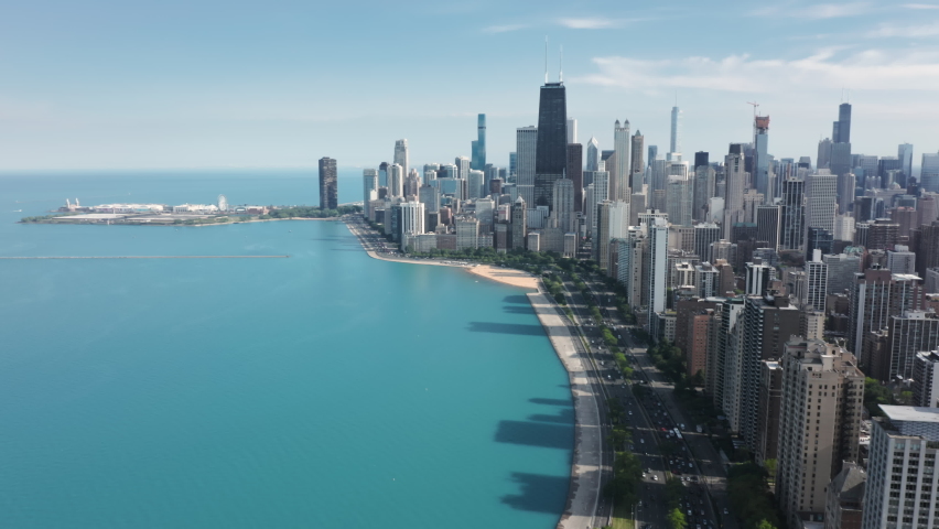 Modern water front buildings with Michigan lake view, USA. Cinematic aerial Chicago coastline with beach. Sunny summer day with copy space on blue green background. Travel business footage, drone 4K.