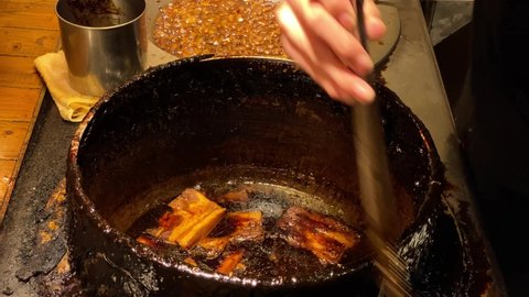 Braised pork belly on dirty braising pot. Prepare for chef cook a slice of stewed meat pig with brown sauce in chinese food style. Traditional taiwanese Dongpo. Taiwan snack street food, Asia.-Dan