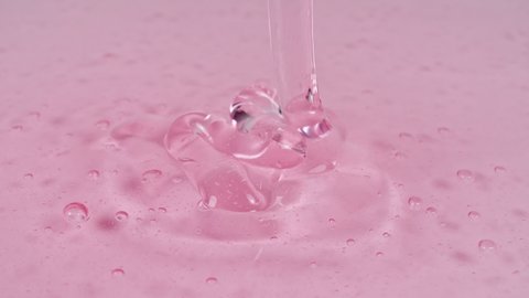 Pouring the Red Cosmetic Gel Cream With Molecule Bubbles. Organic cosmetics, medicine. Macro Shot