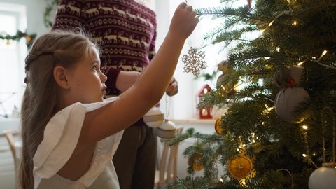 Girl with daddy decorating the Christmas tree. Shot with RED helium camera in 8K 