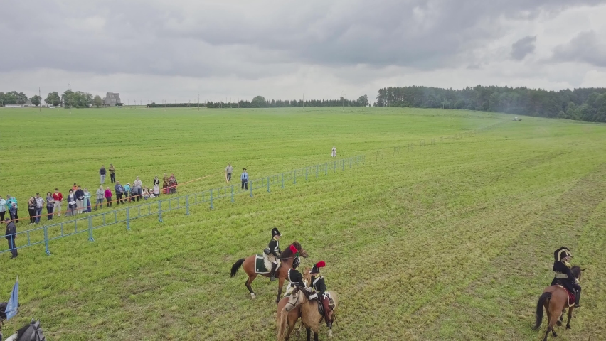 Aerial wide view of reconstruction of the battle of 1812. Soldiers fire cannons and rifles, cavalry gallops. Explosions and shots on the battlefield. Historical concept.