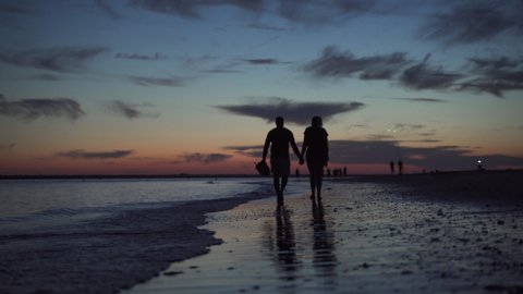 couple walking after the sun fell on the beach