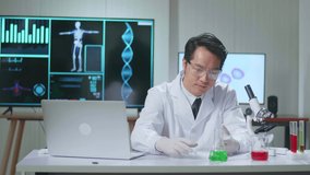 Young Asian Male Research Scientist Holding Glass Test Tube And Speaking To The Camera
