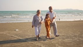 Happy Asian family on summer travel vacation. Grandfather and grandmother walking together with grandchild girl on the beach. Senior couple with granddaughter enjoy and having fun outdoor lifestyle. - Powered by Shutterstock - Get 15% off with code: PIKWIZARD15