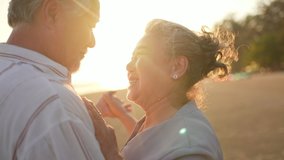 Happy Asian family senior couple holding hand and dancing on the beach together at summer sunset. Elderly retired husband and wife relax and enjoy romantic outdoor holiday vacation with happiness - Powered by Shutterstock - Get 15% off with code: PIKWIZARD15