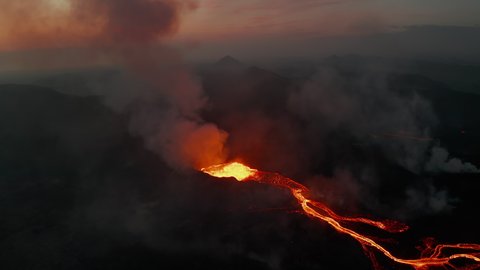 Backwards reveal of branching lava stream flowing down on volcano slope. Crater of active volcano in twilight time. Fagradalsfjall volcano. Iceland, 2021