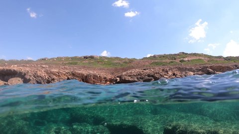 Split Underwater view fo Alghero rocky seabed on a sunny day. Sardinia,Italy