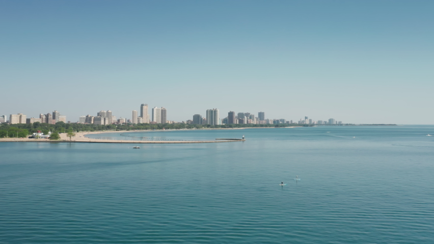 Lake Michigan nature, Illinois USA. 4K aerial panorama of clean light-green lake waters in Chicago bay. Residential front line buildings with beautiful clean water view. Background for travel business