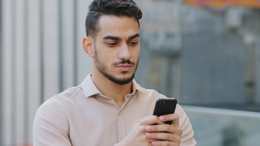 Hispanic amazed businessman receiving sms message offer opportunity, arabian happy man reading good news in smartphone. Excited overjoyed indian male winner celebrating success mobile phone victory | Shutterstock HD Video #1078916696