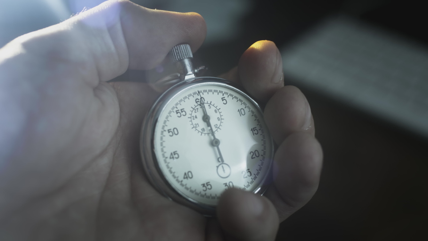 Stopwatch in a man's hand. A man presses the button of a vintage sports metal second watch. Countdown, timer before the event. One person starting up a stopwatch at black background Royalty-Free Stock Footage #1078917227