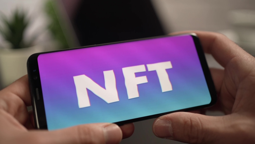 Holding a smartphone with on its screen Non-fungible token NFT being displayed Royalty-Free Stock Footage #1078918253