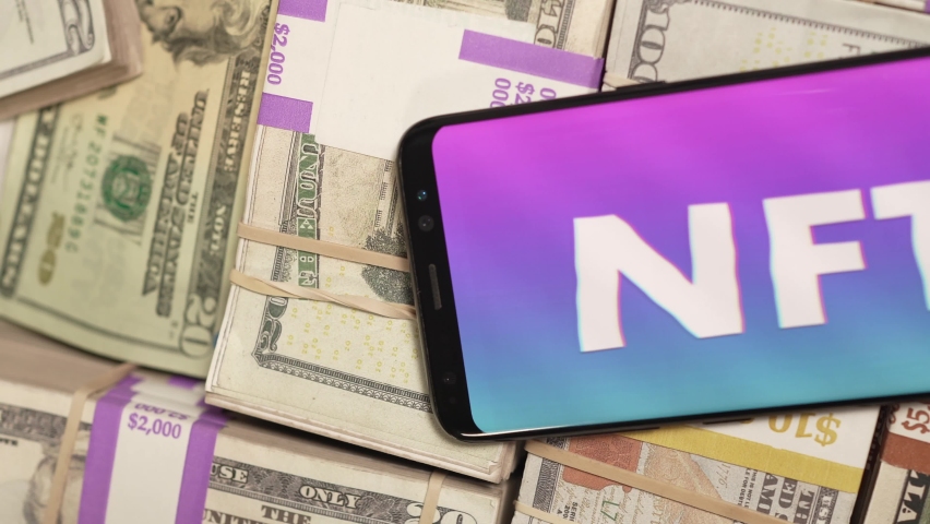 On a pile of cash money a phone showing NFT Non-fungible token on the screen Royalty-Free Stock Footage #1078918271