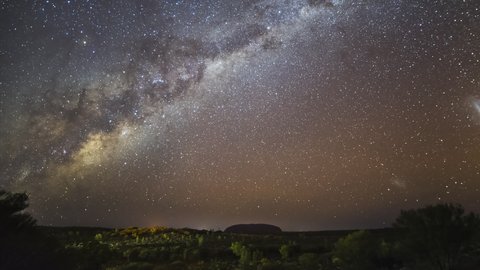 YULARA, AUSTRALIA - JUNE 7 2021: night sky timelapse of the milky way over uluru in uluru-kata tjuta national park of the northern territory